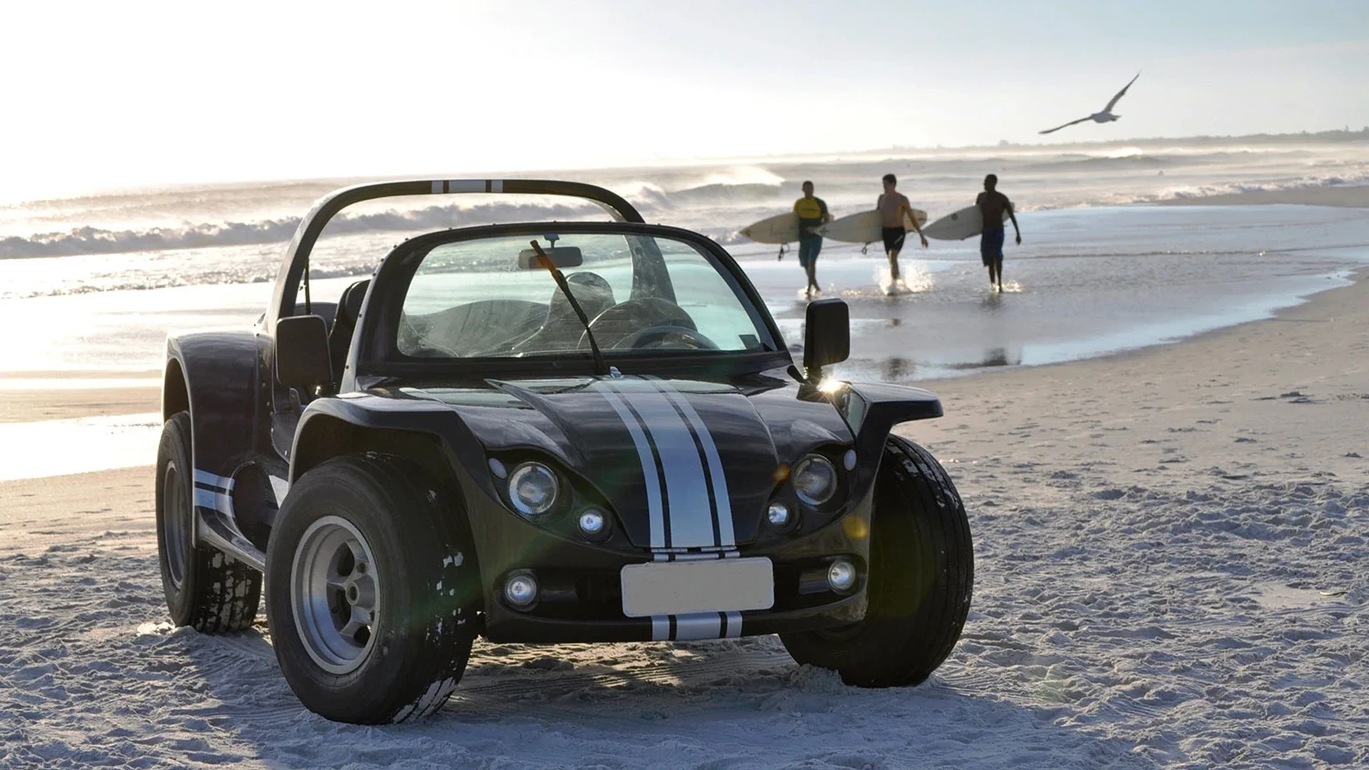 Buggy na areia com mar ao fundo em passeio por Búzios