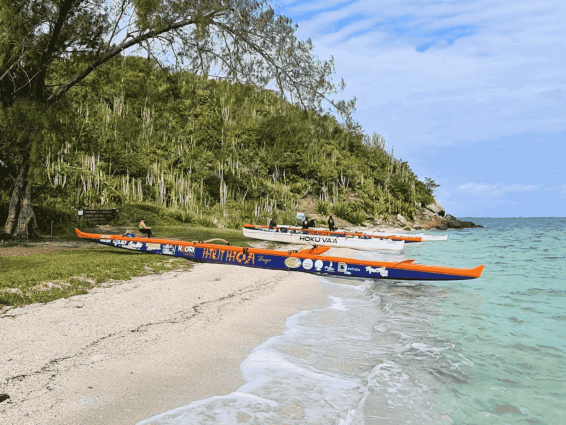 Canoas havaianas na areia à beira de um mar turquesa em Búzios