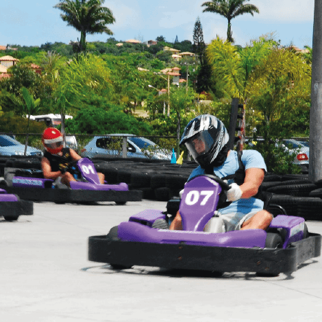 Pilotos de capacete disputam corrida de kart em pista ao ar livre do Radical Parque Búzios